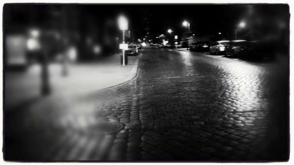 Eine dunkle Starße mit einer einzigen Laterne, die leuchtet: für die Menschenrechte. © Tom Rübenach