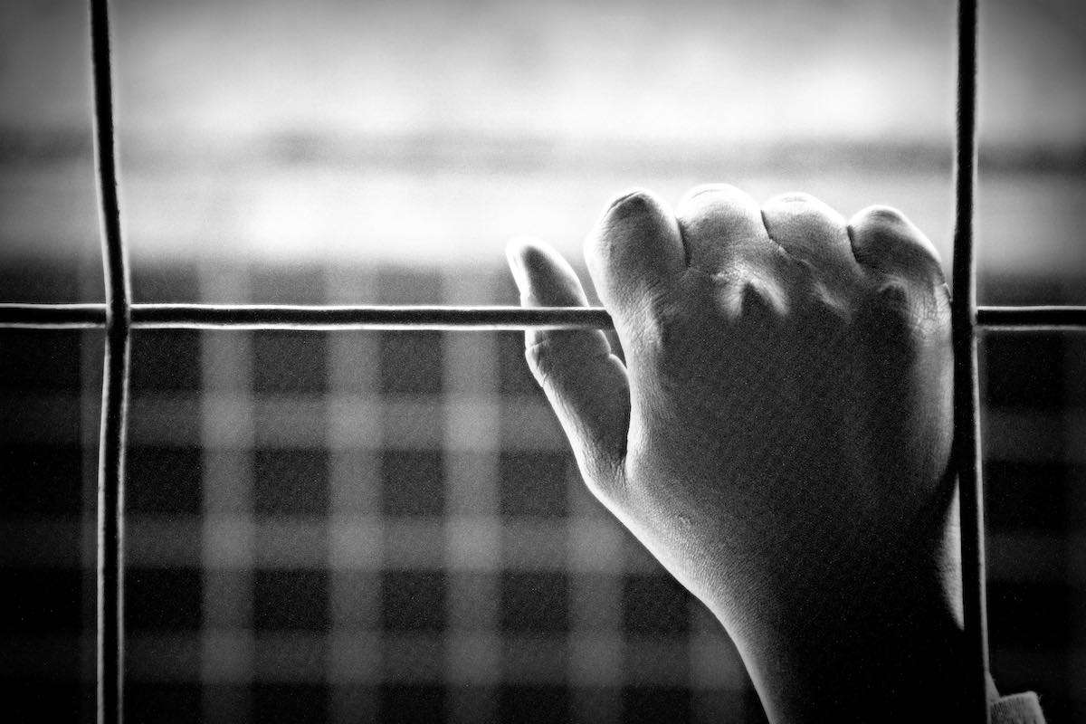 Handrücken an einem Gitter im Slum Korogocho - noch nicht in zeiten von Corona | Photo © Tom Rübenach